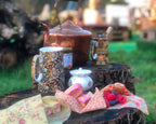 Tea set on a wooden stump outdoors with a blurred background