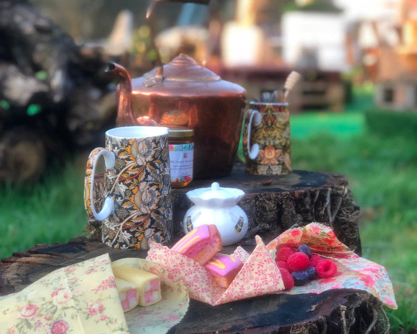 Tea set on a wooden stump outdoors with a blurred background