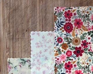 Three floral-patterned cloths on a wooden surface