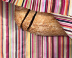 Loaf of bread on a colorful striped fabric background
