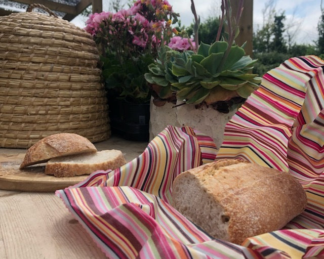 Loaves of bread on a striped cloth with a garden background