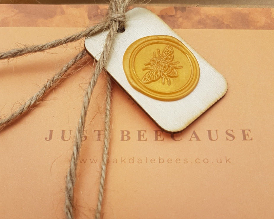 Gift box with a wax seal and 'Just Bee Because' text, featuring a brand logo.