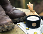 Pair of worn brown boots with a container of leather cream on a surface.