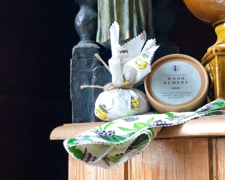 Decorative shelf with a statue, plants, and a small container labeled 'Wood Remedy'.